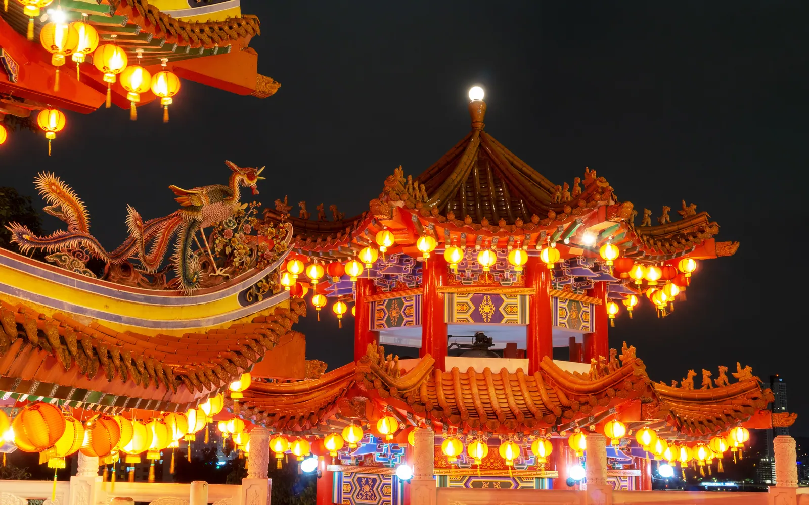 The tiered red roofs and hanging lanterns of a Chinese temple