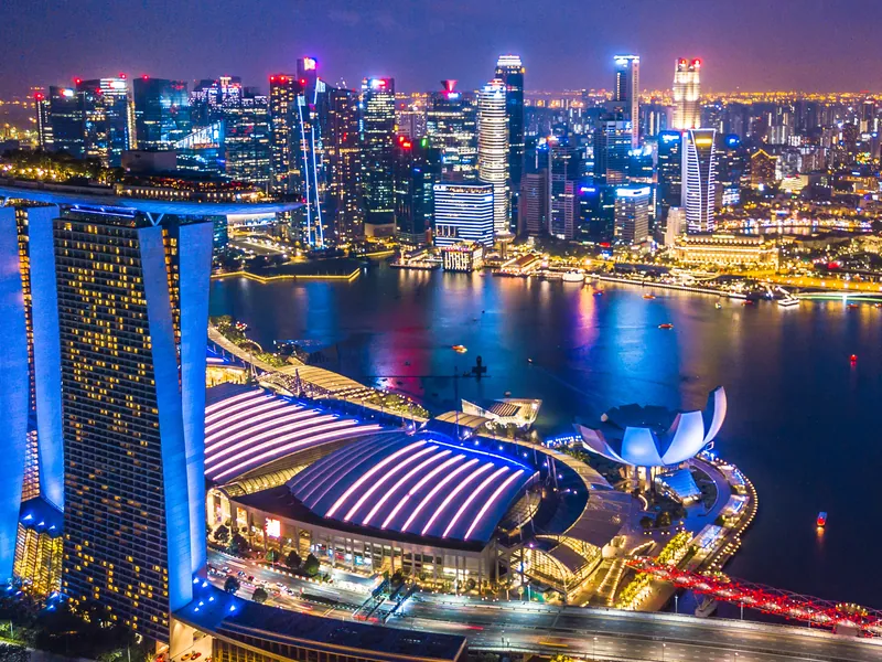 Marina Bay at night, the skyline reflected in still water