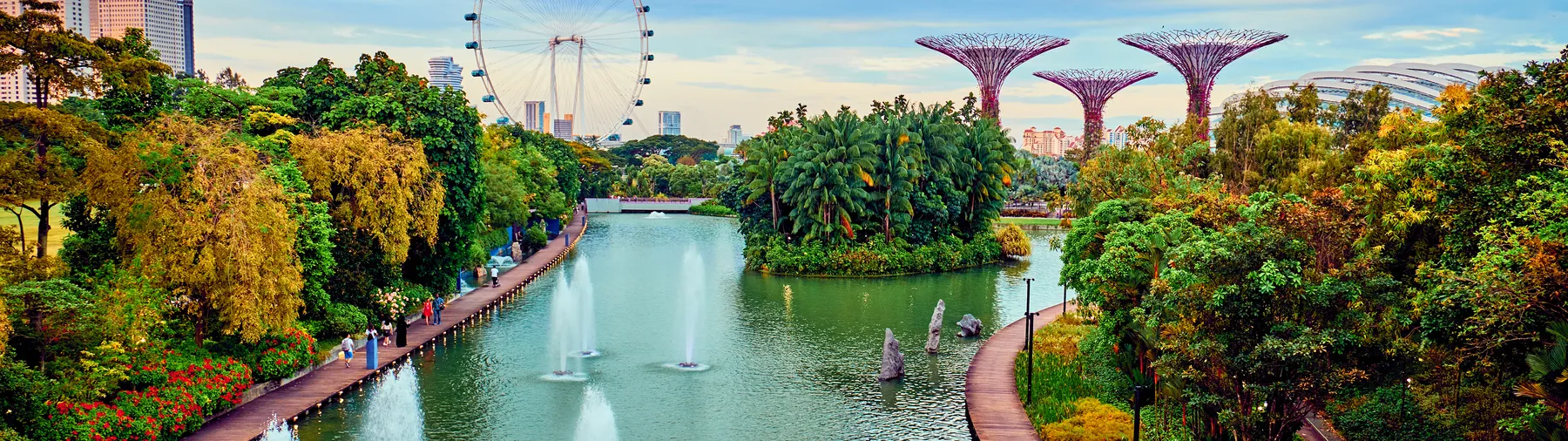 Fountains and greenery in the gardens with the city skyline behind