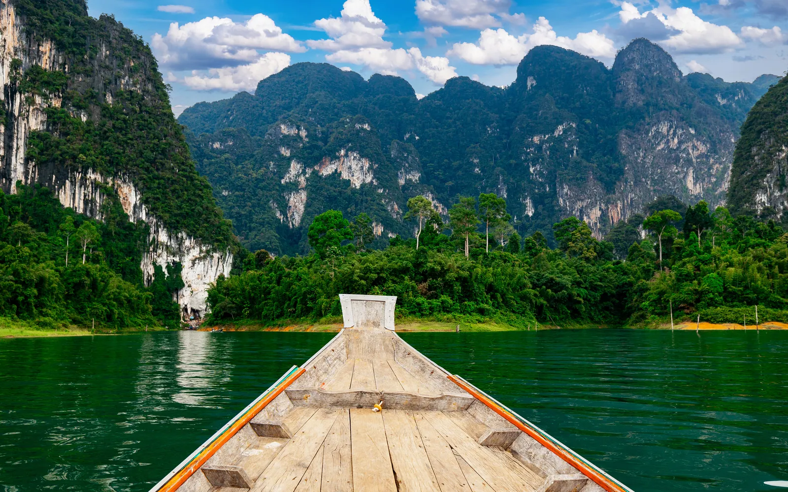 The bow of a longtail boat heading into limestone karsts on Cheow Lan lake, Khao Sok
