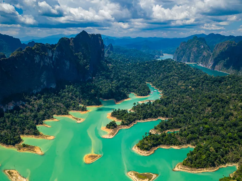 Cheow Lan lake from the air, green water winding between forested limestone peaks