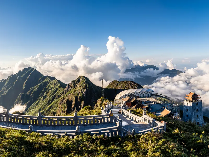 A cable car station and temple complex above the clouds on a mountain