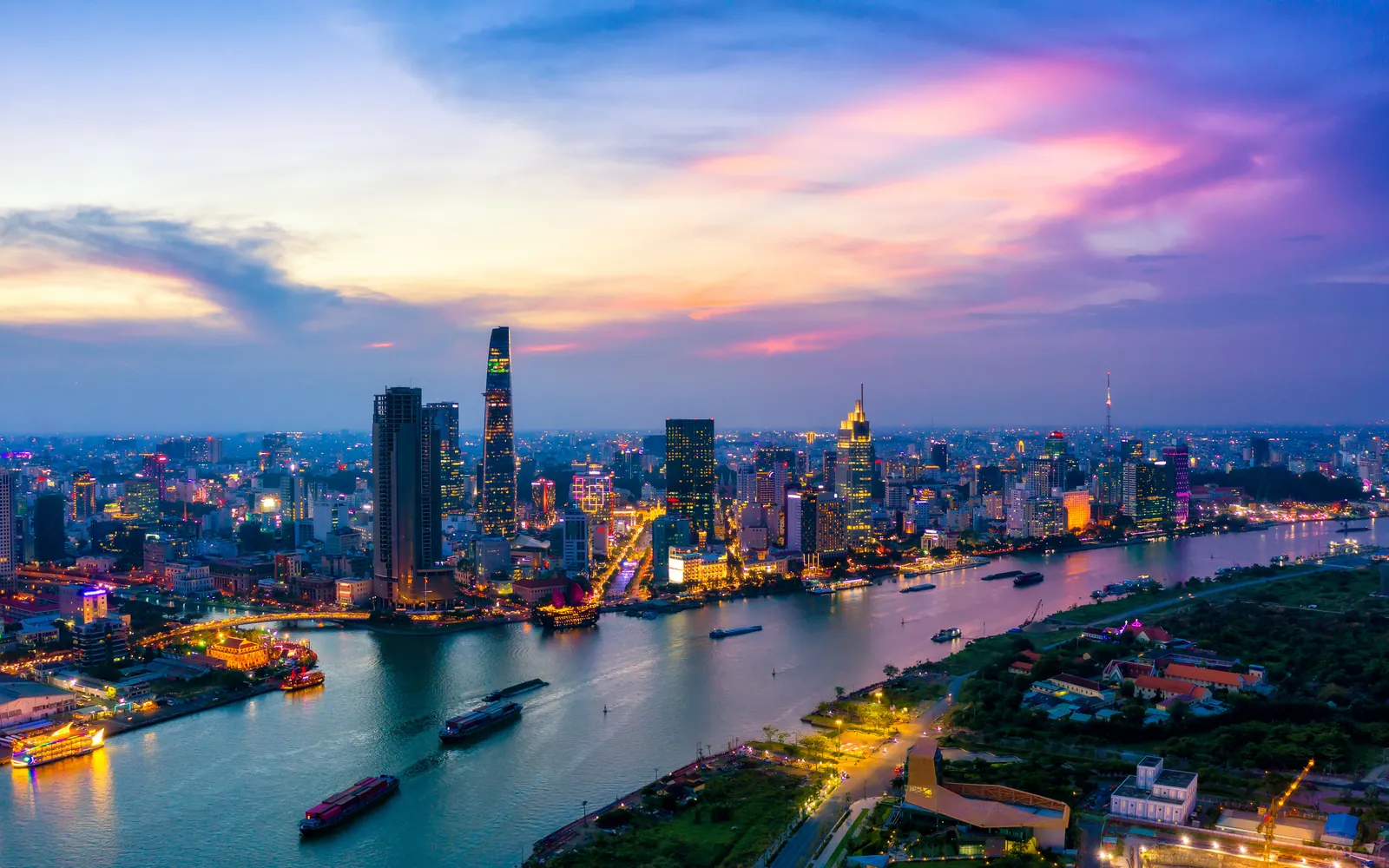 Ho Chi Minh City at dusk with the river curving through the lit skyline